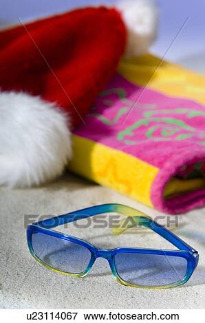 Stock Photo - Santa hat, beach towel, sunglasses. Fotosearch