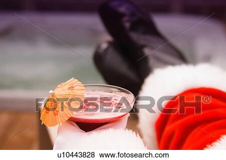 Stock Photo - Santa holding tropical drink. Fotosearch