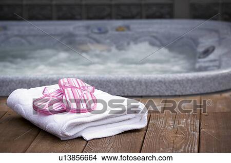 Picture - Thongs and towel next to hot tub. Fotosearch