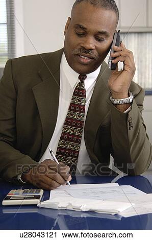 Stock Image - African American businessman on cordless phone. Fotosearch