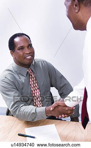 Stock Image - African American businessmen shaking hands. Fotosearch