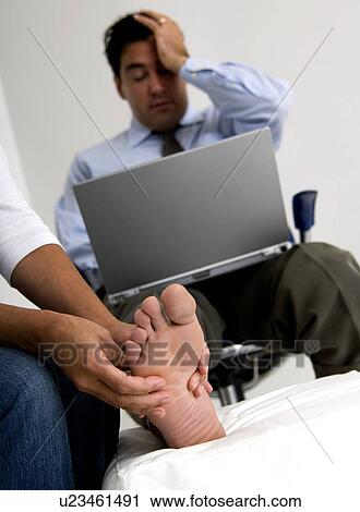 Businessman with laptop getting foot massage View Large Photo Image Stock Image - Businessman with laptop getting foot massage. Fotosearch