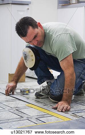 Construction worker laying new flooring View Large Photo Image Stock Photo - Construction worker laying new flooring. Fotosearch