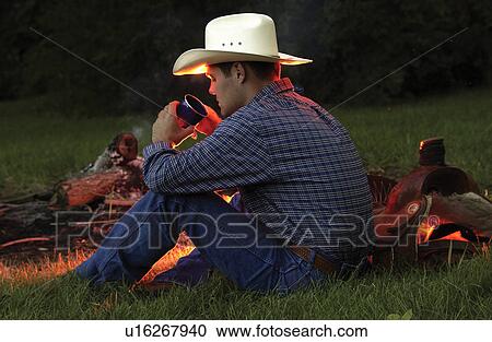 Stock Image - Cowboy near campfire. Fotosearch