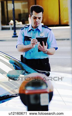 Stock Image - Policeman writing parking ticket. Fotosearch