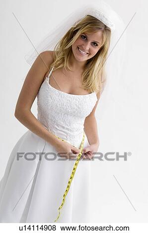 Bride measuring her waist View Large Photo Image Stock Photo - Bride measuring her waist. Fotosearch
