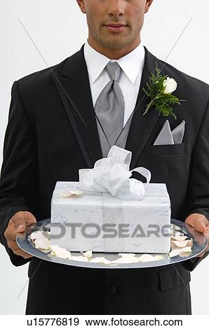 Groom with gift on silver platter View Large Photo Image Stock Photo - Groom with gift on silver platter. Fotosearch