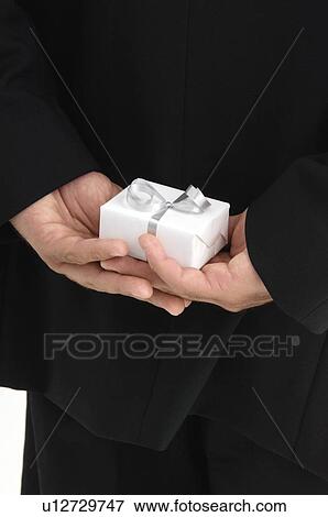 Man holding gift behind his back View Large Photo Image Stock Photo - Man holding gift behind his back. Fotosearch