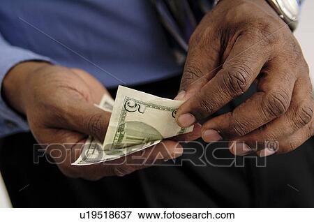 Stock Photo - Businessman holding money. Fotosearch