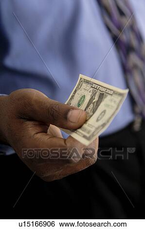 Stock Photograph - Businessman holding money. Fotosearch