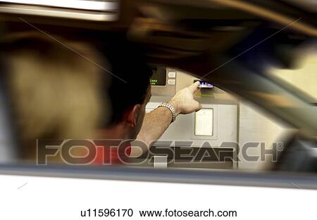 Stock Image - Couple in car at ATM. Fotosearch
