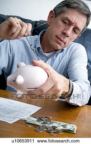 Man raiding piggy bank View Large Photo Image Stock Image - Man raiding piggy bank. Fotosearch