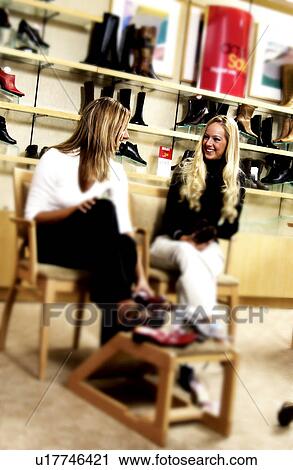 Stock Image - Two women in shoe store. Fotosearch