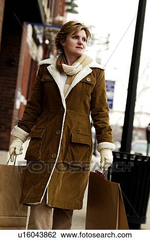 Stock Image - Woman carrying shopping bags. Fotosearch