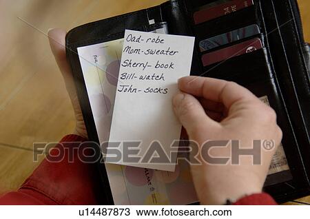 Woman looking at Christmas shopping list View Large Photo Image Stock Image - Woman looking at Christmas shopping list. Fotosearch