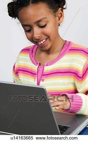 Stock Photography - African American girl working on laptop. Fotosearch