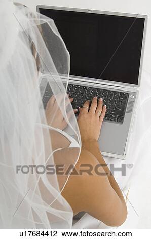 Stock Image - Bride using laptop. Fotosearch