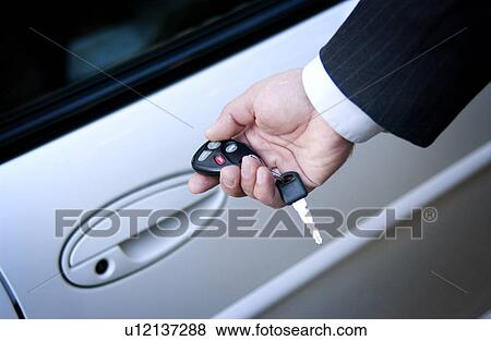 Stock Photo - Businessman locking or unlocking car door. Fotosearch
