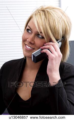 Businesswoman at desk talking on cordless phone View Large Photo Image Stock Photo - Businesswoman at desk talking on cordless phone. Fotosearch