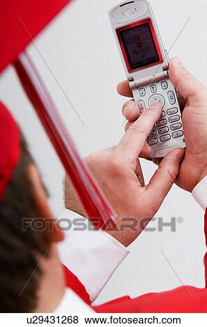 Graduate dialing cell phone View Large Photo Image Stock Photo - Graduate dialing cell phone. Fotosearch