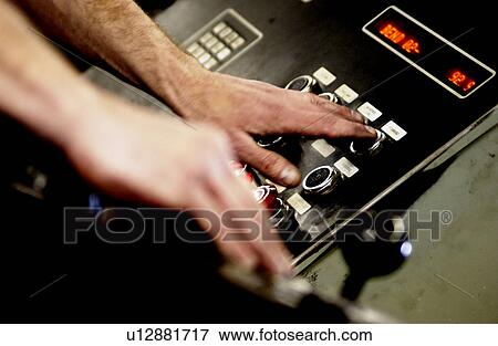 Stock Photo - Man in factory using control panel. Fotosearch