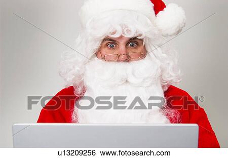 Stock Photograph - Santa with laptop. Fotosearch
