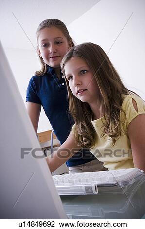 Stock Image - Two girls at computer. Fotosearch