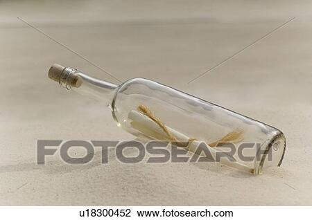 Stock Image - Message in a bottle on beach. Fotosearch