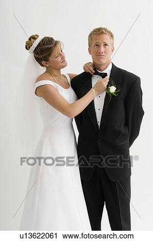 Bride fixing groom's bow tie View Large Photo Image Stock Image - Bride fixing groom's bow tie. Fotosearch