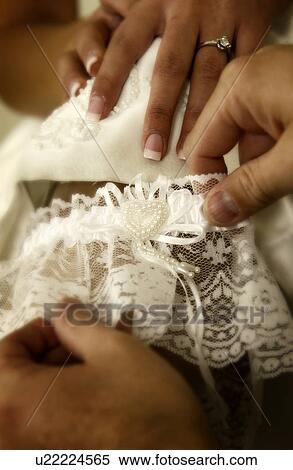 Groom taking garter off brides leg View Large Photo Image Stock Photography - Groom taking garter off brides leg. Fotosearch