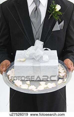 Groom with gift on silver platter View Large Photo Image Stock Photo - Groom with gift on silver platter. Fotosearch