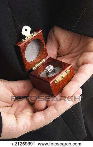 Man holding ring in box behind his back View Large Photo Image Stock Image - Man holding ring in box behind his back. Fotosearch