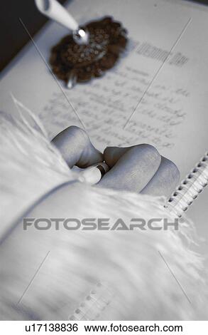 Stock Photograph - Woman signing wedding guest book. Fotosearch