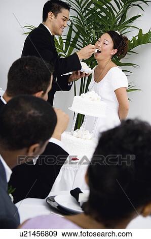 Bride and groom cutting cake View Large Photo Image Stock Photo - Bride and groom cutting cake. Fotosearch