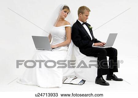 Stock Image - Bride and groom on laptops. Fotosearch