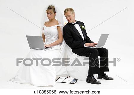 Bride and groom on laptops View Large Photo Image Stock Photograph - Bride and groom on laptops. Fotosearch