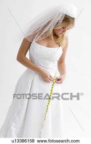 Stock Photo - Bride measuring her waist. Fotosearch