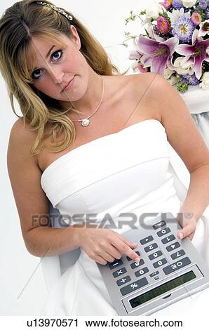Stock Image - Bride using calculator. Fotosearch
