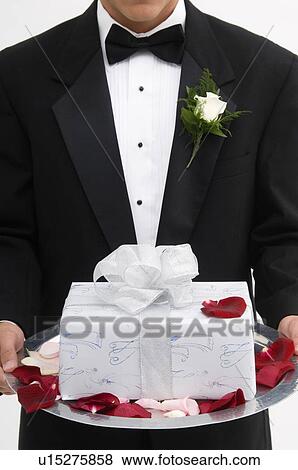 Man holding gift on a silver platter View Large Photo Image Stock Photo - Man holding gift on a silver platter. Fotosearch