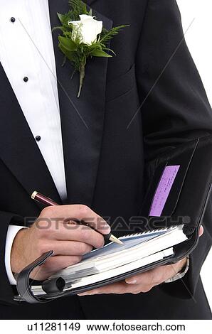 Stock Photo - Man writing in daily business planner. Fotosearch