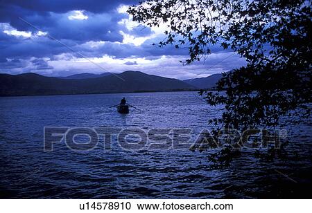 Man in boat in lake View Large Photo Image Stock Image - Man in boat in lake. Fotosearch