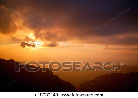 Stock Image - Mountain silhouettes in sunset sky. Fotosearch