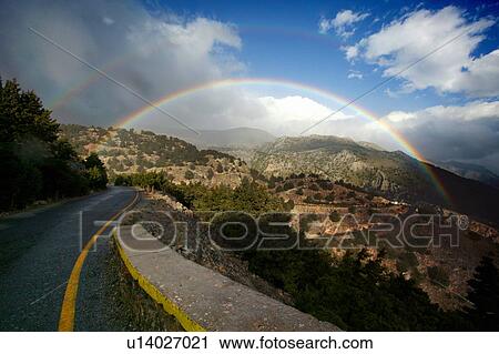 Stock Image - Rainbow on countryside road. Fotosearch