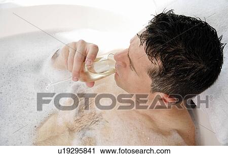Stock Image - Man relaxing in bathtub with bubbles. Fotosearch