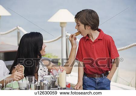 Stock Photo - Mother feeding son in a cafe. Fotosearch