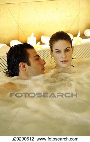 Stock Image - One man with one woman in jacuzzi at a spa. Fotosearch