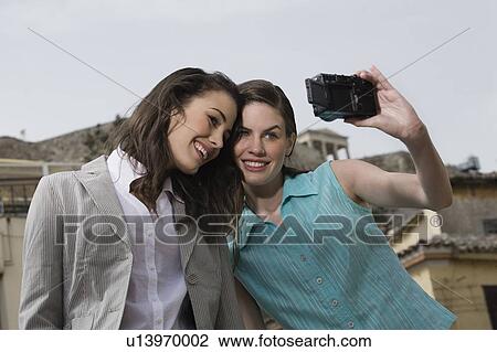 Two women photographing themselves View Large Photo Image Stock Image - Two women photographing themselves. Fotosearch