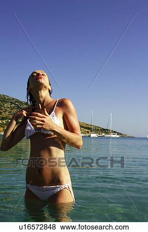 Stock Photo - Young woman at the beach in water. Fotosearch