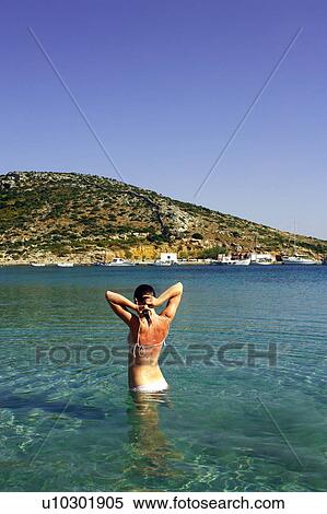 Stock Photography - Young woman at the beach in water. Fotosearch