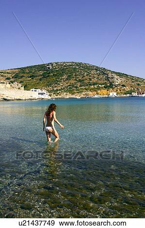 Stock Photo - Young woman at the beach wading in water. Fotosearch